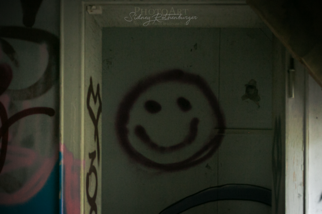 blutrotes Smiley auf einer gefliesten Wand in der Villa Sohl - Anekdote